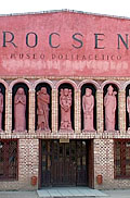 Vista del frente rosado con el acceso al Museo Polifacético Rocsen, Nono. Sobre la Linea de la puerta hay estatuas de figuras humanas a escala real