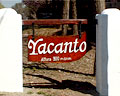 Señalización de acceso a Yacanto, pilares sosteniendo pieza rústica de madera